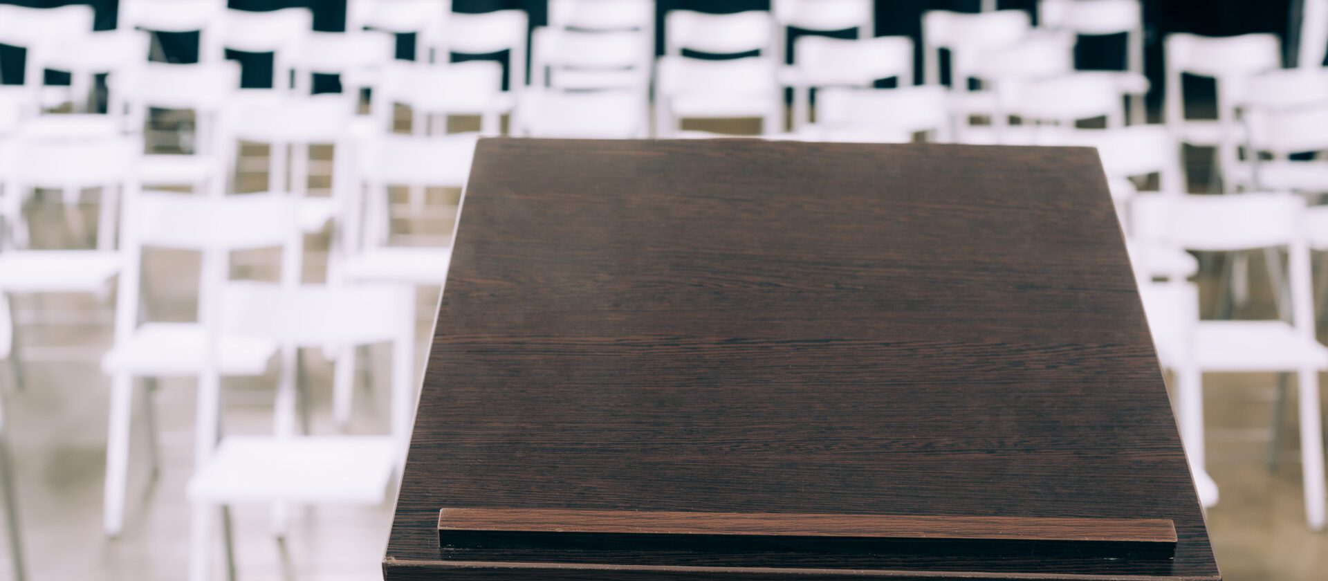 podium tribune and empty white chairs in conference hall